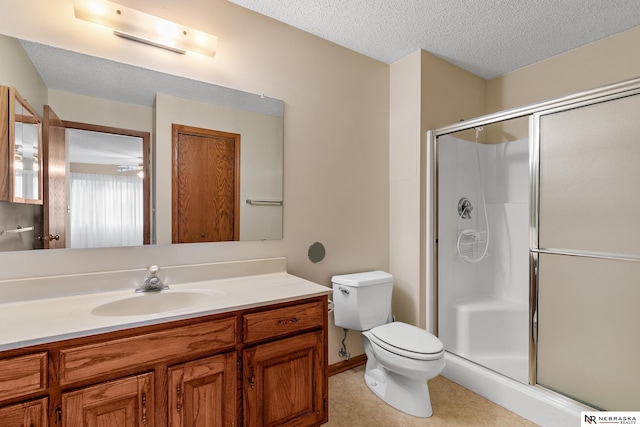 bathroom featuring vanity, an enclosed shower, a textured ceiling, and toilet