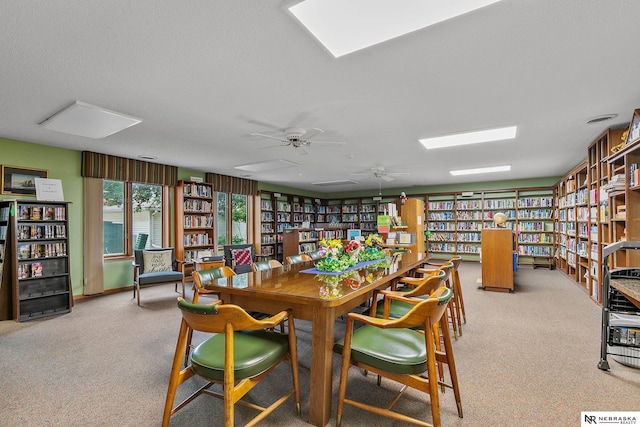 dining space featuring a textured ceiling and light colored carpet