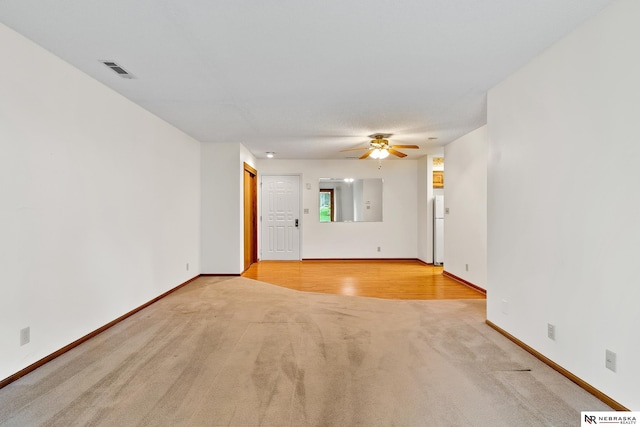 unfurnished room with ceiling fan and light carpet