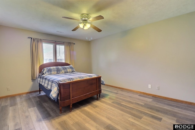 bedroom featuring hardwood / wood-style flooring, ceiling fan, and a textured ceiling