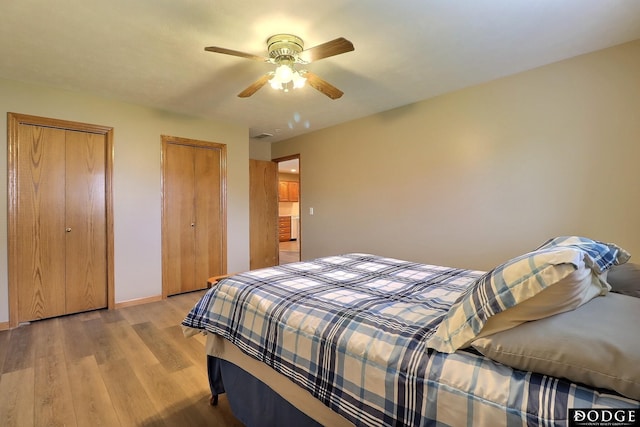 bedroom featuring multiple closets, ceiling fan, and light hardwood / wood-style floors