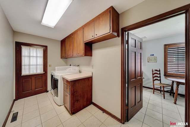 laundry area featuring light tile patterned flooring, cabinets, and washer and dryer