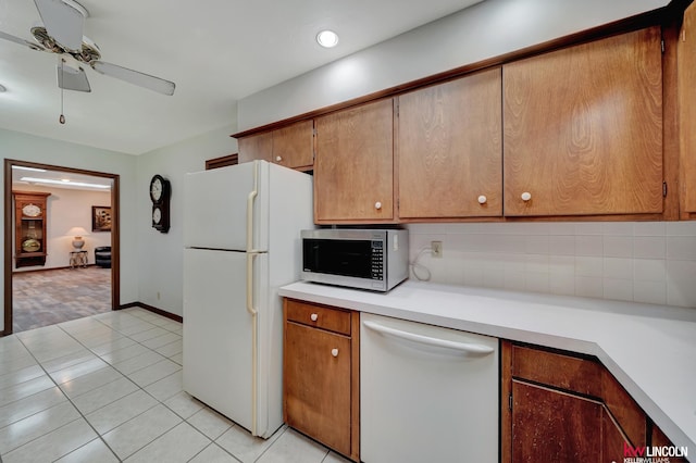 kitchen featuring decorative backsplash, white appliances, light tile patterned floors, and ceiling fan