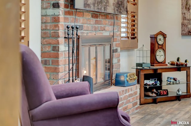 living area with a healthy amount of sunlight, a fireplace, and hardwood / wood-style floors