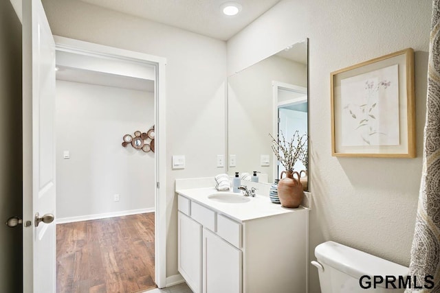 bathroom featuring hardwood / wood-style flooring, vanity, and toilet