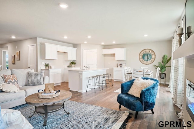 living room featuring sink and light hardwood / wood-style floors