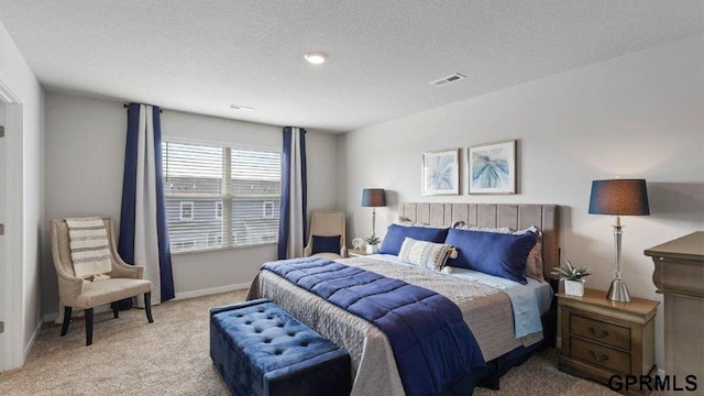 bedroom featuring light colored carpet and a textured ceiling