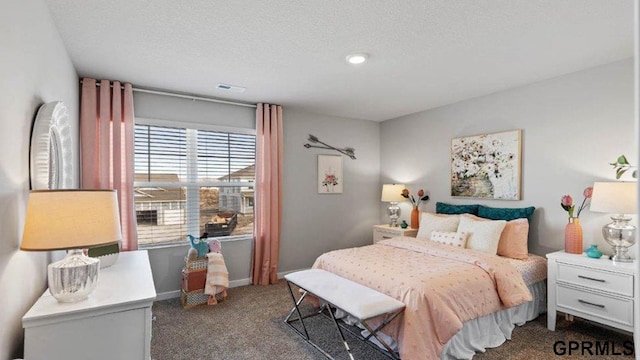 bedroom featuring a textured ceiling and dark colored carpet