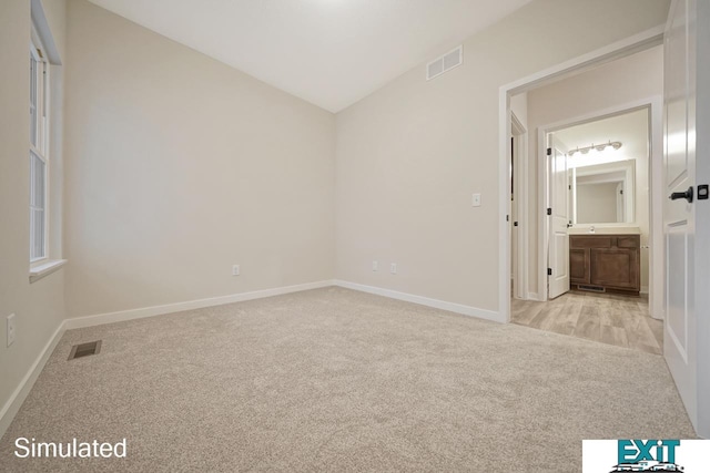 unfurnished room with lofted ceiling and light colored carpet