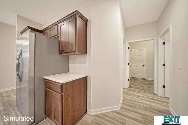 kitchen with stainless steel refrigerator with ice dispenser and light hardwood / wood-style floors