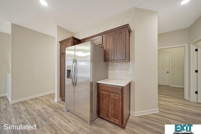 kitchen with light wood-type flooring and stainless steel fridge with ice dispenser