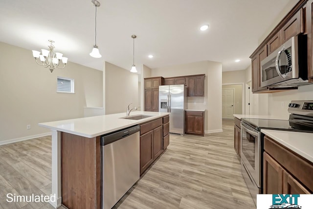 kitchen featuring light hardwood / wood-style flooring, appliances with stainless steel finishes, a notable chandelier, sink, and a kitchen island with sink