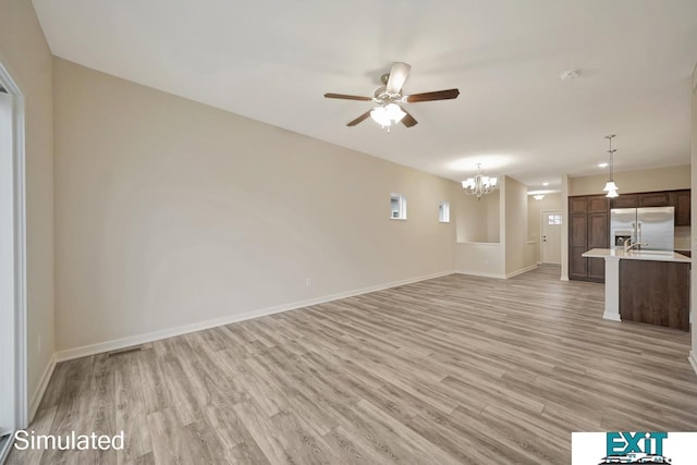 unfurnished living room with ceiling fan with notable chandelier and light hardwood / wood-style floors