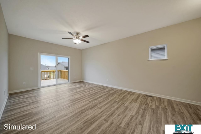 empty room with hardwood / wood-style floors and ceiling fan