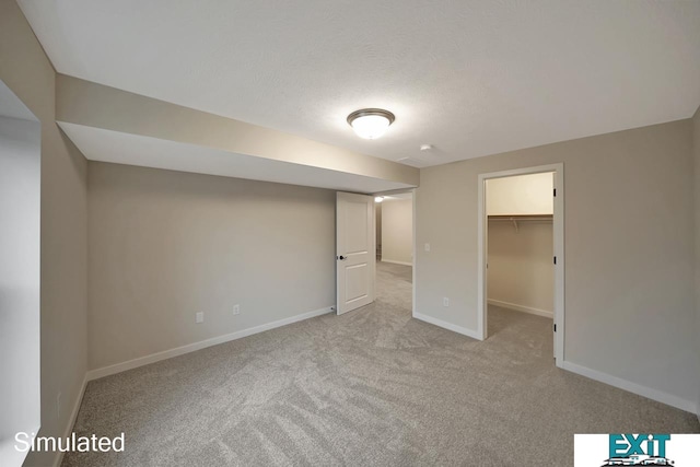 unfurnished bedroom featuring a walk in closet, light colored carpet, and a closet