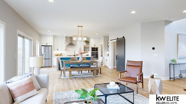 living room with light hardwood / wood-style floors and a barn door