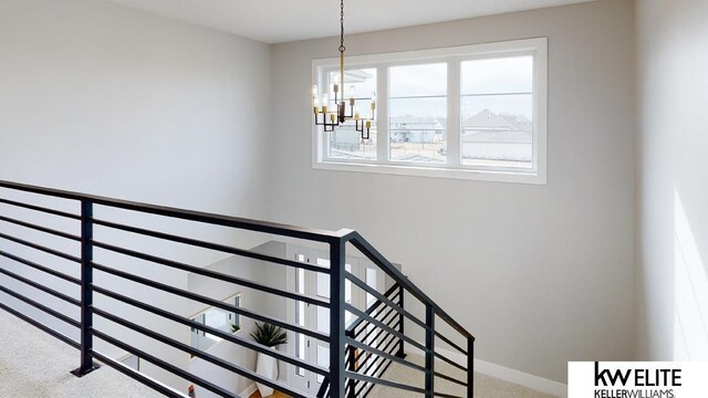 staircase featuring a notable chandelier and carpet