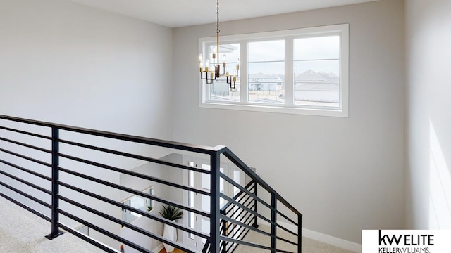 stairway with baseboards, a chandelier, and carpet flooring