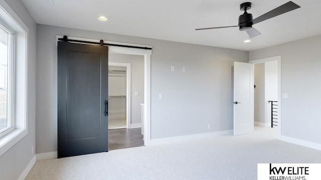 carpeted bedroom featuring a barn door, baseboards, a ceiling fan, and recessed lighting