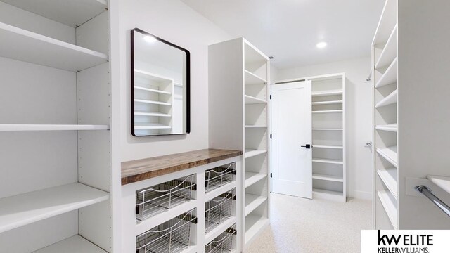 walk in closet featuring light carpet