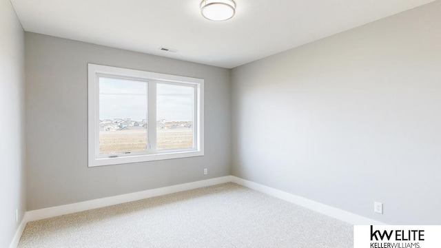 carpeted spare room with baseboards and visible vents