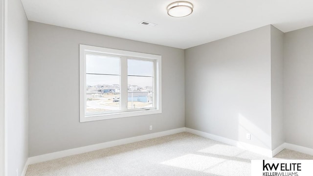 carpeted empty room featuring visible vents and baseboards