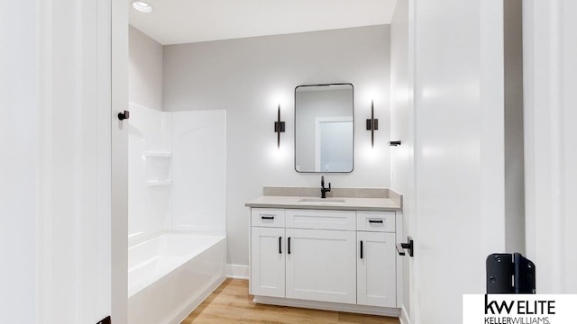 full bath featuring bathing tub / shower combination, vanity, and wood finished floors