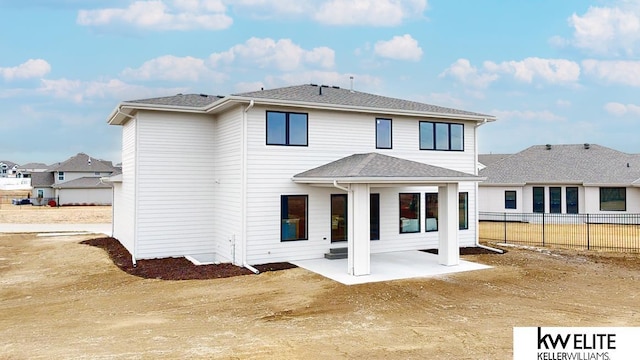 back of house featuring a shingled roof, a patio, and fence