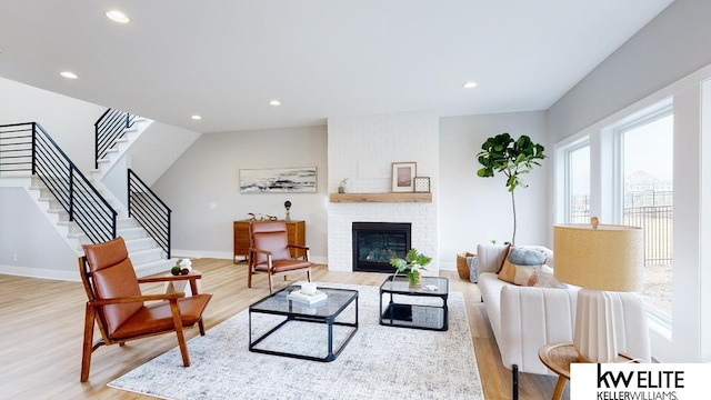 living room with a fireplace and light wood-type flooring