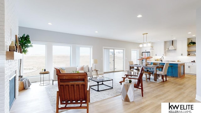 living room featuring sink, a fireplace, and light hardwood / wood-style flooring