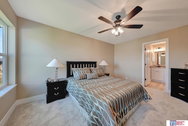 carpeted bedroom with multiple windows, ceiling fan, and ensuite bathroom