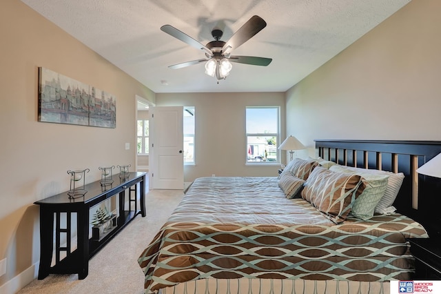 carpeted bedroom with a textured ceiling and ceiling fan