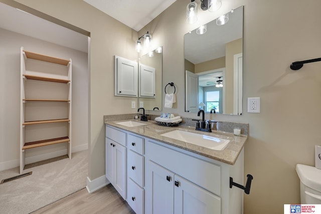 bathroom featuring hardwood / wood-style floors, ceiling fan, vanity, and toilet