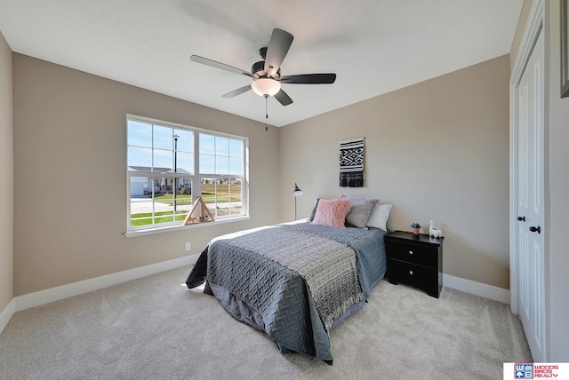 carpeted bedroom featuring ceiling fan and a closet