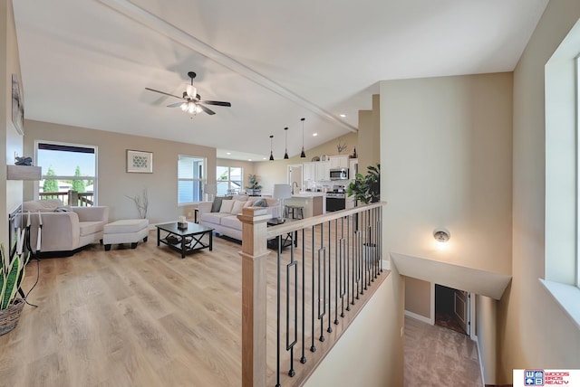 hallway featuring light hardwood / wood-style flooring and lofted ceiling