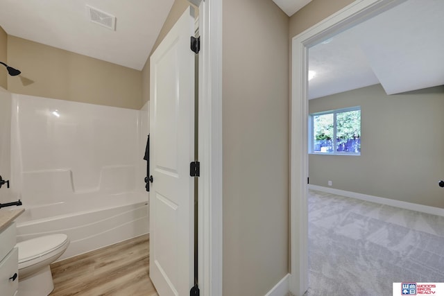 full bathroom featuring washtub / shower combination, vanity, toilet, and hardwood / wood-style floors