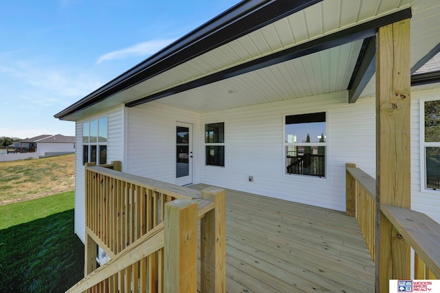 wooden terrace featuring a yard