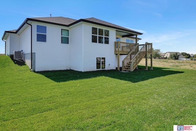 rear view of house featuring central AC unit, a deck, and a yard