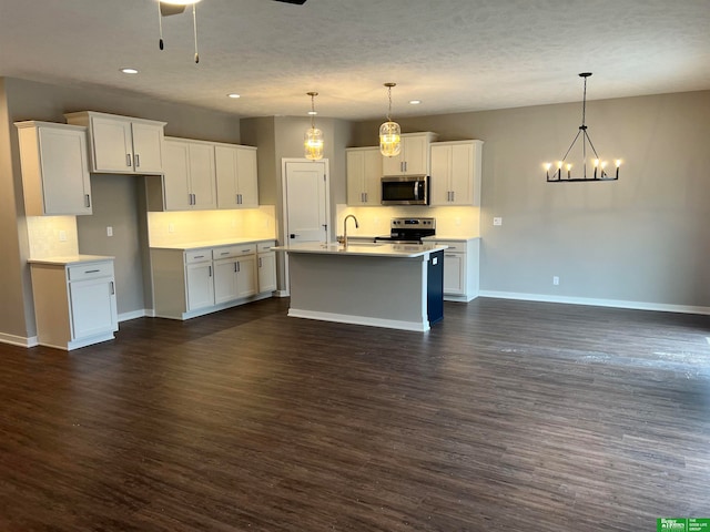 kitchen with appliances with stainless steel finishes, dark hardwood / wood-style floors, hanging light fixtures, and white cabinets