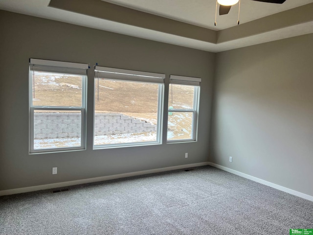 empty room featuring carpet, a wealth of natural light, and ceiling fan