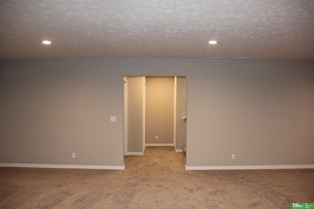 carpeted empty room with a textured ceiling