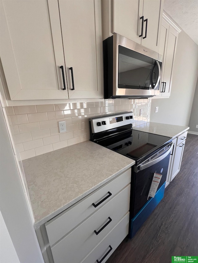 kitchen featuring appliances with stainless steel finishes, dark wood-type flooring, white cabinets, and tasteful backsplash