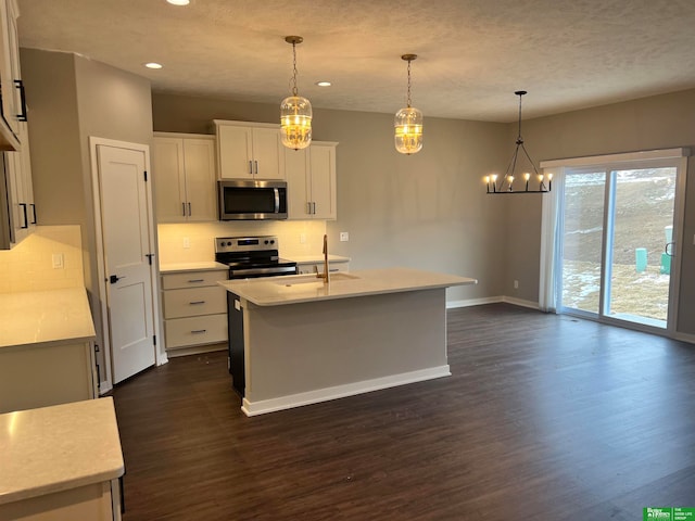 kitchen featuring tasteful backsplash, stainless steel appliances, white cabinets, decorative light fixtures, and dark hardwood / wood-style flooring