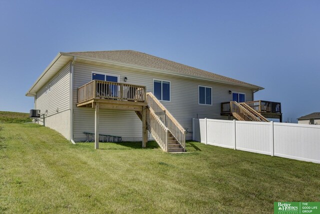 rear view of house featuring cooling unit, a yard, a wooden deck, and stairs