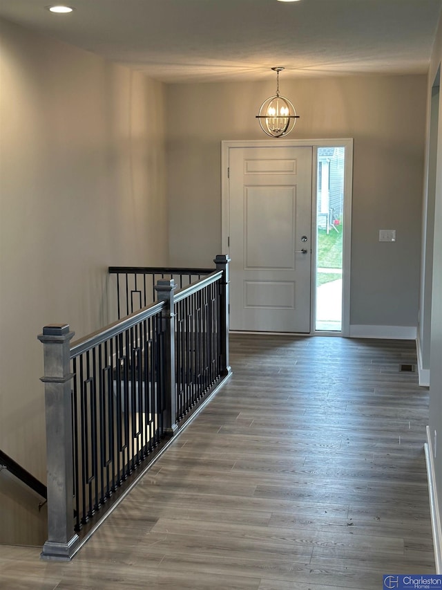 entryway with hardwood / wood-style flooring and a chandelier