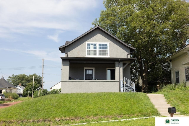 view of front facade featuring covered porch and a front lawn