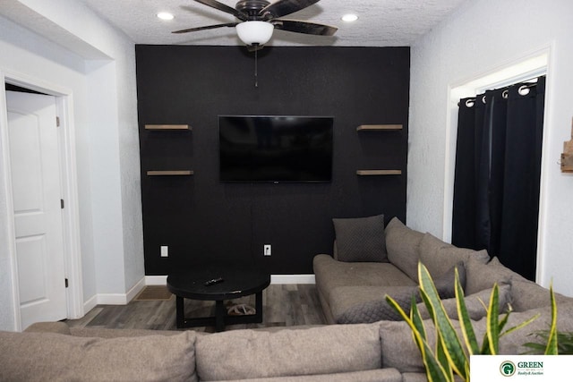 living room featuring hardwood / wood-style flooring, a textured ceiling, and ceiling fan