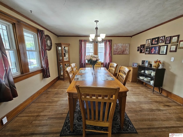 dining area with dark wood-style floors, a chandelier, crown molding, and baseboards