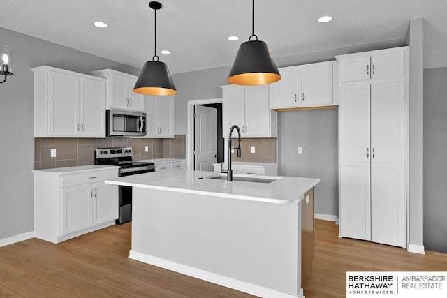 kitchen with backsplash, stainless steel appliances, and white cabinetry