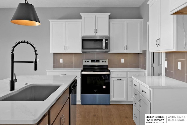 kitchen featuring tasteful backsplash, white cabinetry, light hardwood / wood-style floors, and stainless steel appliances